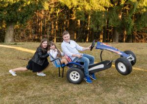 Lustiges Kinderfoto im eigenen Garten. Familienporträt zu Hause von Linz bis Amstetten.