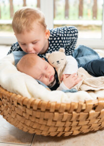 Newbornbild mit Schwester. Babyfotografin in Perg