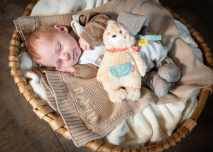 Newbornfoto zu Hause. Baby liegt im Körbchen.
