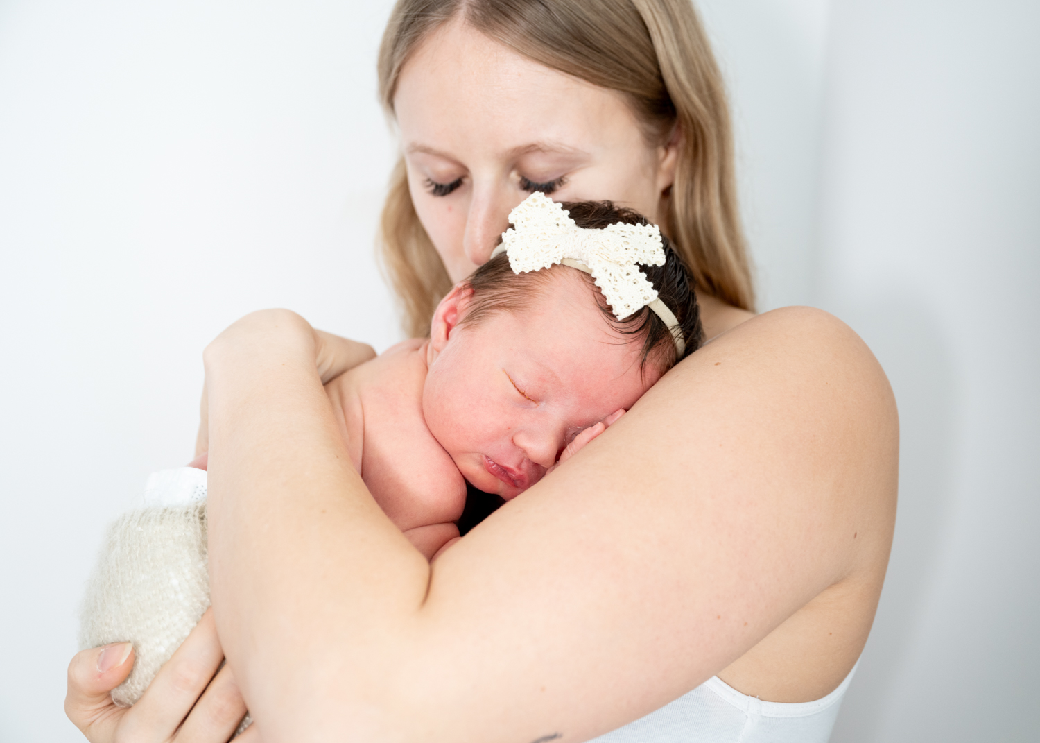 Neugeborenes Baby schläft bei Mama am Arm. Baby fotografie zu Hause in Mitterkirchen.